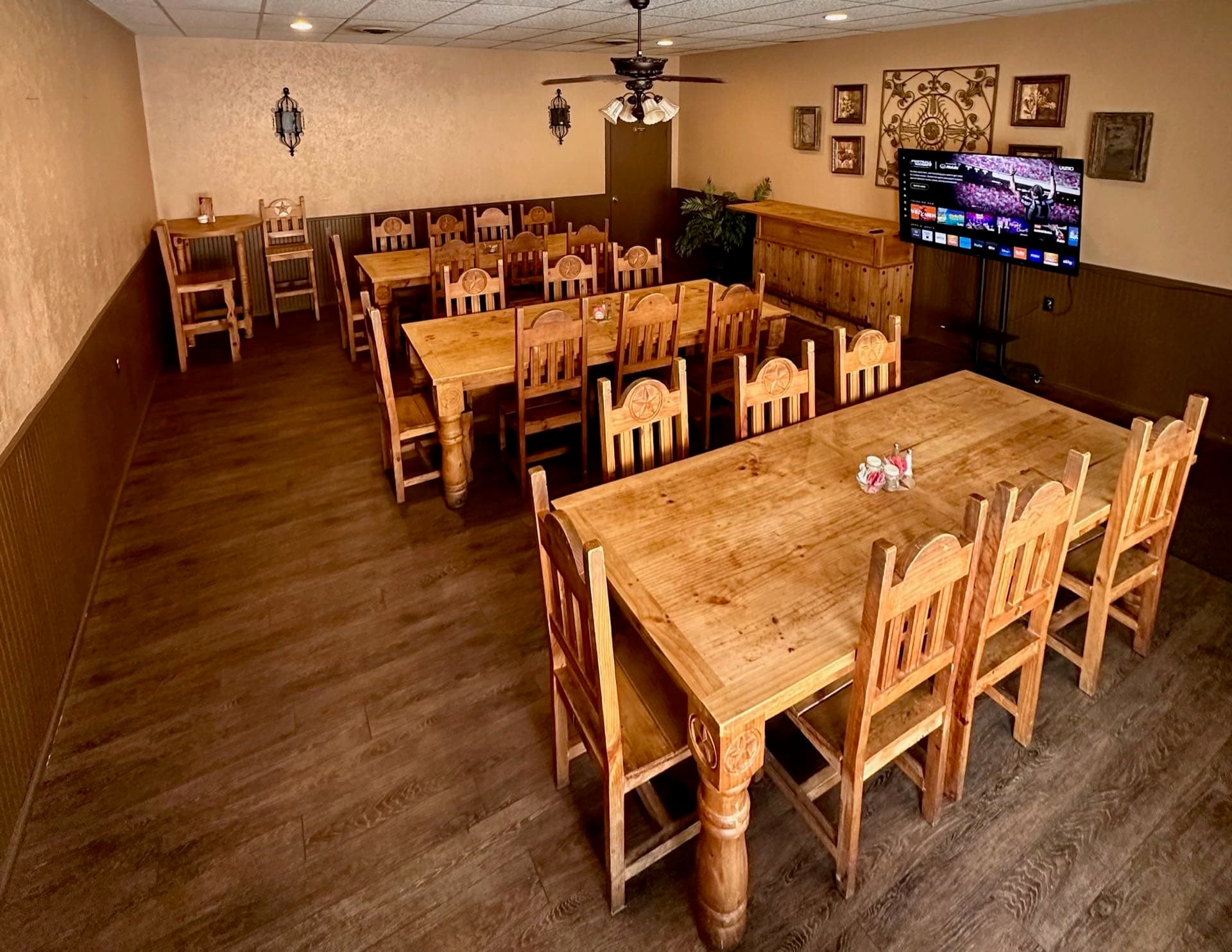 The private party room at Texas Traditions, set with long communal tables and a wall-mounted TV.
